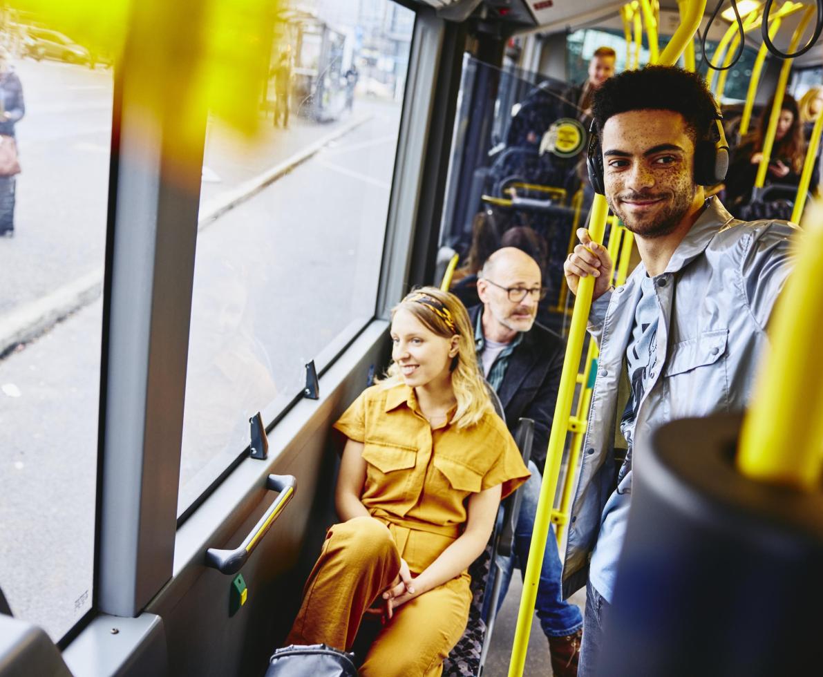 Smiling people looking outside from the bus.