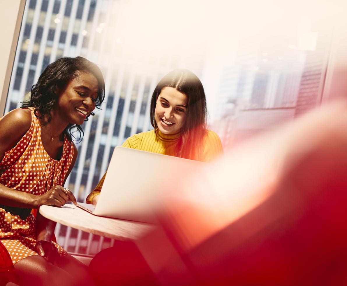 Two smiling women working together