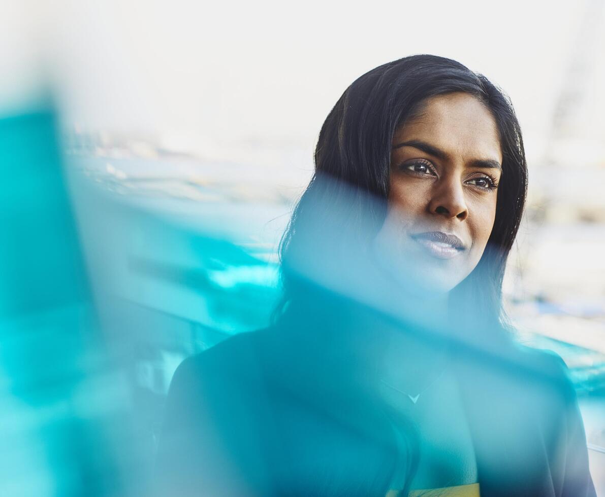 Young woman in harbor. India. Primary color: blue.