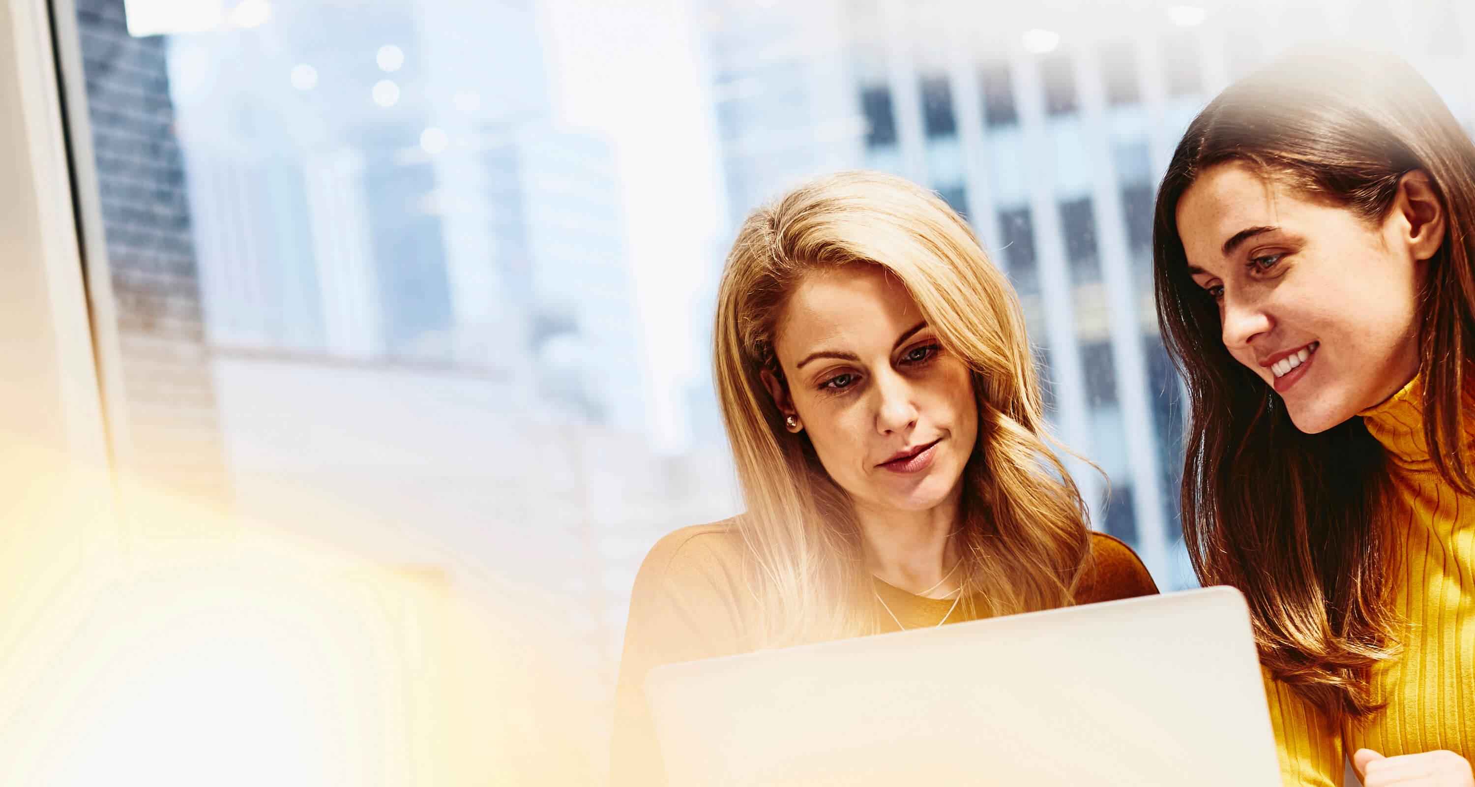 deux femmes regardant un ordinateur