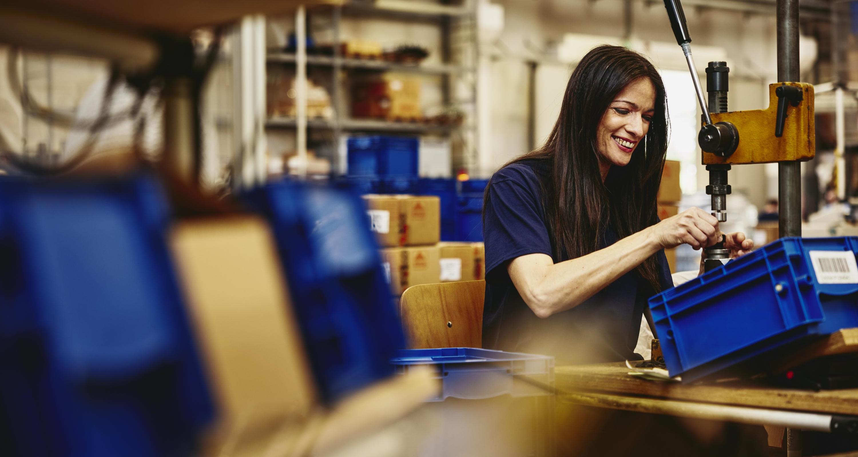 Smiling woman working on a production site.