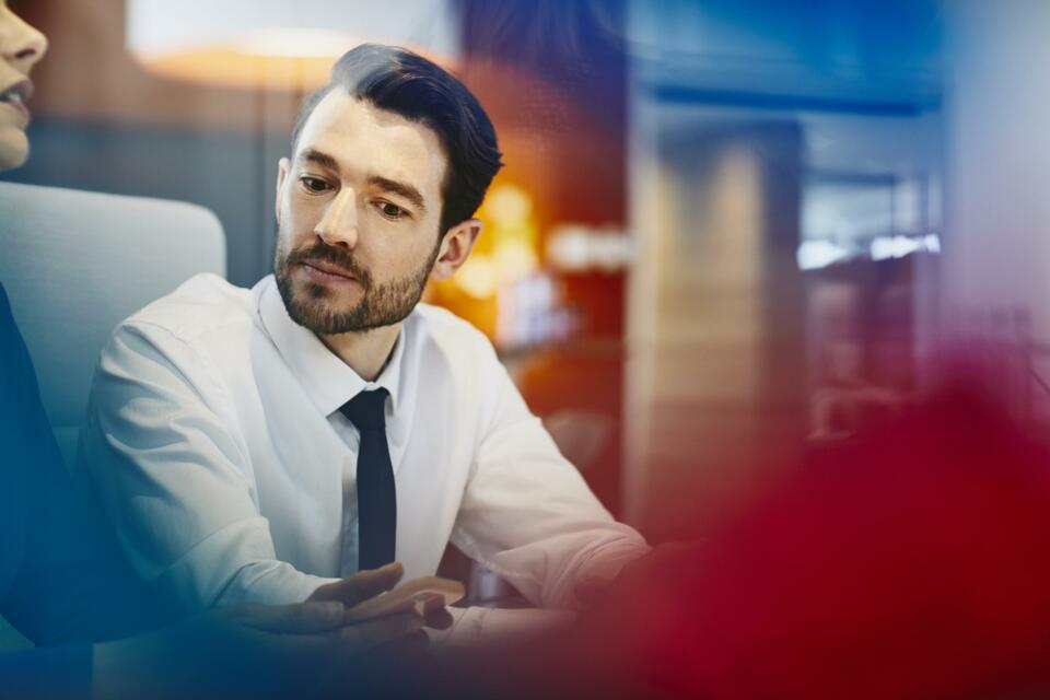 Man with tie listening. Primary color: red.